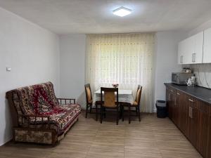 a kitchen and dining room with a table and a couch at Casa David in Mălăeşti +10 photos
