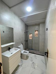 a bathroom with a toilet and a sink and a shower at Oumaira Residence Azla-Tetouan in Azla +62 photos