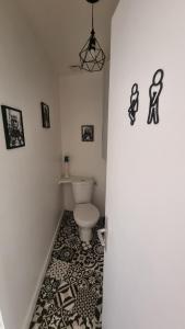 a bathroom with a toilet and a black and white tile floor at Chez Gabin in Tartas