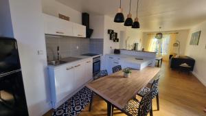 a kitchen and dining room with a wooden table at Chez Gabin in Tartas