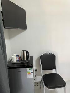 a chair sitting next to a small refrigerator with a microwave at Lungi and Rendzo Guesthouse in Alberton