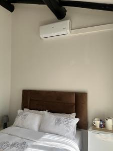 a bedroom with a white bed with a brown headboard at Lungi and Rendzo Guesthouse in Alberton