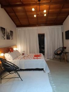 a bedroom with a large bed and a chair at Chalé Recanto da Chiquinha in Santa Teresa