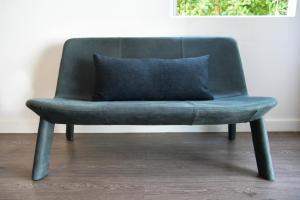 a green chair with a blue pillow on it at Hollywood Guesthouse in Los Angeles