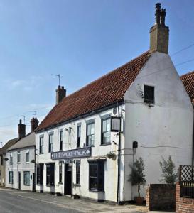 a white building on the side of a street at The Wolf's Den in Patrington