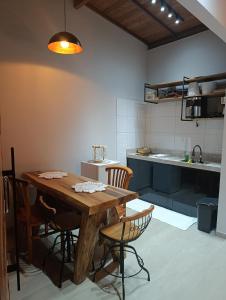 a kitchen with a wooden table and chairs at Chalé Recanto da Chiquinha in Santa Teresa