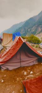 a tent in a field with mountains in the background at Glacier view point kedarnath in Kedārnāth