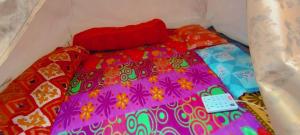 a bed with a colorful comforter and pillows at Glacier view point kedarnath in Kedārnāth
