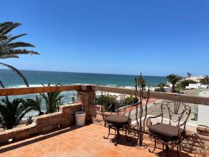 a patio with chairs and the ocean in the background at Ocean Front Baja Vacation in Rosarito +23 photos