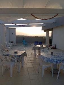 a patio with tables and chairs on a roof at Villa Maldera-case vacanza-loft- loft queen specchio in Trani