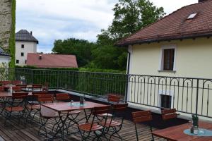 a patio with tables and chairs and a fence at Zum Schlosswirt in Fürsteneck