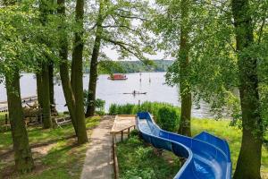 a blue slide next to a lake with a boat at Tiny House WICA in Königs Wusterhausen