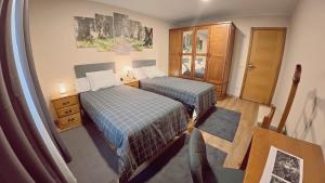 a bedroom with two beds and a dresser at A Casa de Moire in Arnois
