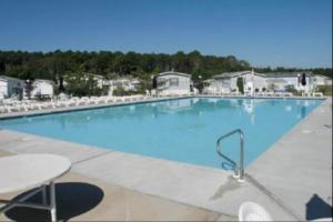 a large blue swimming pool with a table and chairs at Assateague Point - Bay Breeze in Berlin