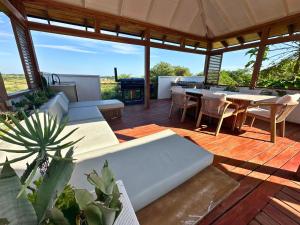 a pavilion with a table and chairs on a deck at Aloha 28 in Ponta Mamoli