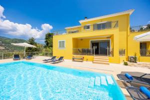 a villa with a swimming pool in front of a house at Villa Inna in Mikros Gialos