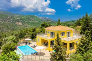 an aerial view of a yellow house with a swimming pool at Villa Inna in Mikros Gialos
