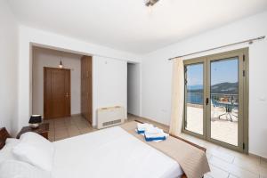 a bedroom with a large bed and a balcony at Villa Inna in Mikros Gialos +33 photos