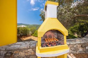 a yellow oven with a fire inside of it at Villa Inna in Mikros Gialos