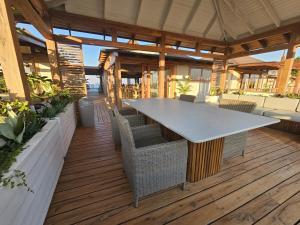 an outdoor patio with a large table and chairs at Aloha 28 in Ponta Mamoli
