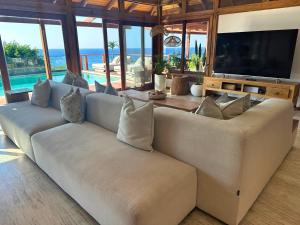 a living room with a couch and a television at Aloha 28 in Ponta Mamoli +28 photos