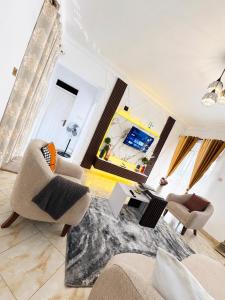 a living room with two chairs and a table at LyzHomes in Kampala
