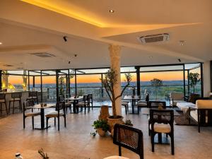 ein Restaurant mit Tischen, Stühlen und Fenstern in der Unterkunft Saint John Hotel in Madaba