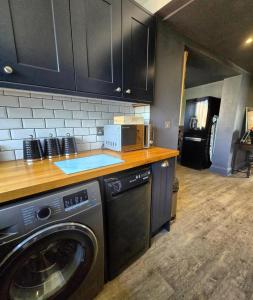 a kitchen with a washing machine and a microwave at The Wolf's Den in Patrington