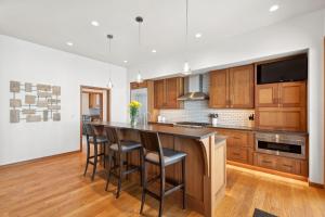 a kitchen with wooden cabinets and a bar with stools at Rivers End Lake House in Bigfork +52 photos