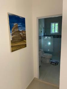a bathroom with a painting on the wall and a toilet at top apartments in Santo Domingo +2 photos