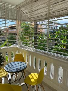 a balcony with yellow chairs and a table and windows at top apartments in Santo Domingo