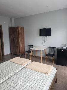 a room with two beds and a table with chairs at French Hotel in Kobuleti
