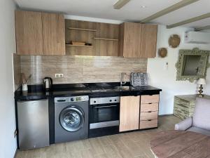 a kitchen with a stove and a washing machine at palmeraie4 in Skhirat