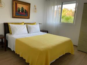 a bedroom with a bed with a yellow blanket on it at palmeraie4 in Skhirat