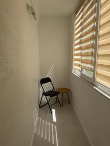 a chair sitting in a room with a window at Sunny Apartment in Otaci