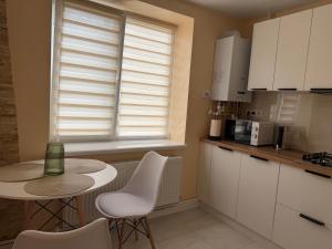 a kitchen with a table and chairs and a window at Sunny Apartment in Otaci