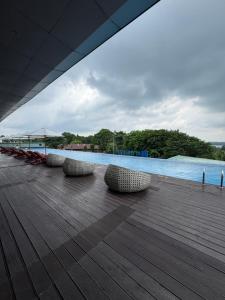 a group of chairs sitting on a deck next to the water at Panbil Residence Apartment - Studio 2 Bed in Bagam