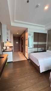 a bedroom with a large bed and a kitchen at Panbil Residence Apartment - Studio 2 Bed in Bagam