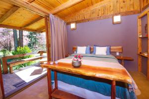 a bedroom with a bed and a balcony at Espaço Gata Mourisca in Camanducaia
