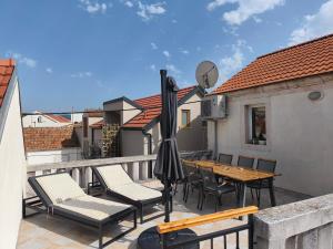 a balcony with a table and chairs and an umbrella at Apartments Ani in Vela Luka