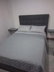 a bedroom with a large bed with a black headboard at Apartaestudio en Cali in Cali