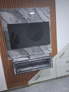 a flat screen tv on top of a marble wall at Apartaestudio en Cali in Cali