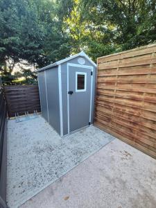 a small grey shed next to a wooden fence at Carabois in Esson