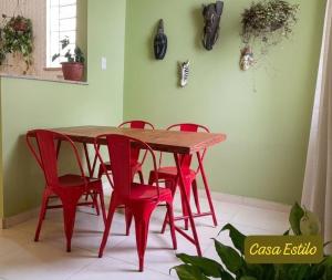 a red dining room table and red chairs in a room at Casa Estilo - São Lourenço in São Lourenço +8 photos