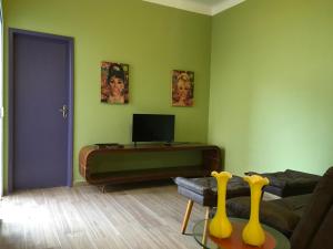 a living room with a couch and a tv at Casa Estilo - São Lourenço in São Lourenço