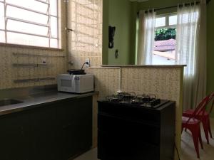 a kitchen with a stove and a microwave on a counter at Casa Estilo - São Lourenço in São Lourenço