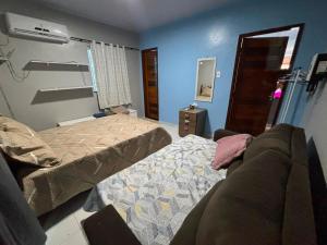 a bedroom with two beds and a couch in it at Casapalmares in Parintins +2 photos