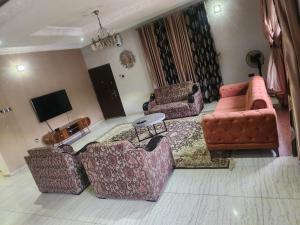 a living room with two couches and a tv at Afiraiserviceapartment in Kaduna