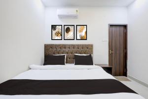 a bedroom with a large bed with four pictures on the wall at Hotel O White House in Rānchī