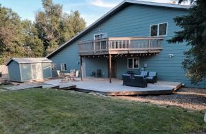 a house with a large deck with a patio at Dakota Lodge in Dickinson